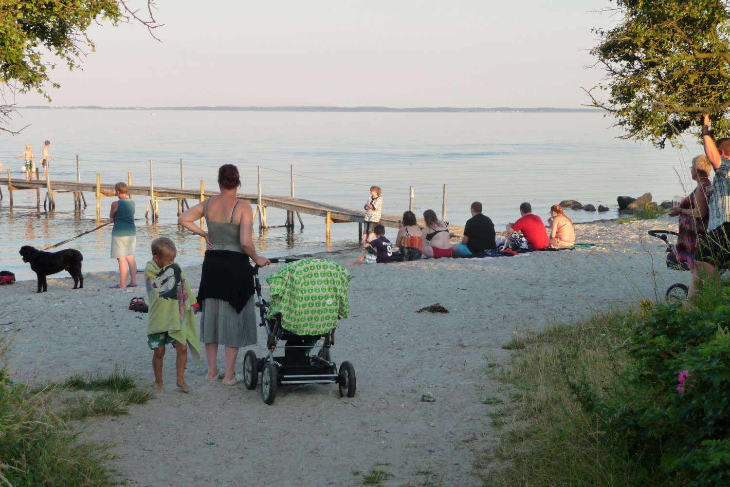 Familier nyder aftensolen ved stranden