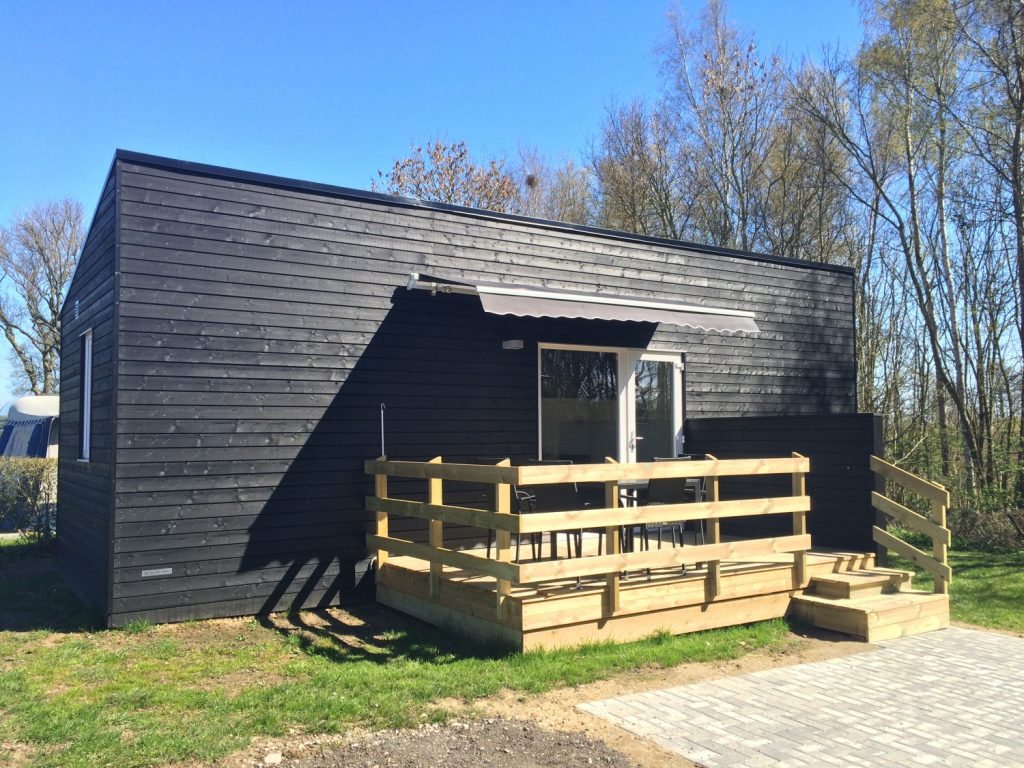 Sort luksushytte med terrasse og markise